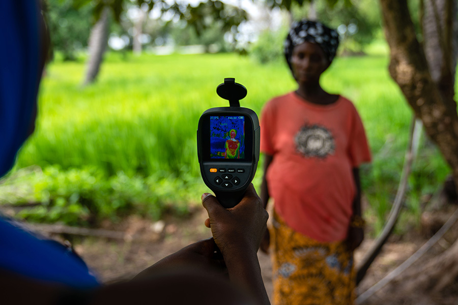 Field worker uses a thermal imaging camera to measure mother and her unborn baby&#039;s temperature in Keneba, The Gambia. Credit: Louis Leeson/LSHTM