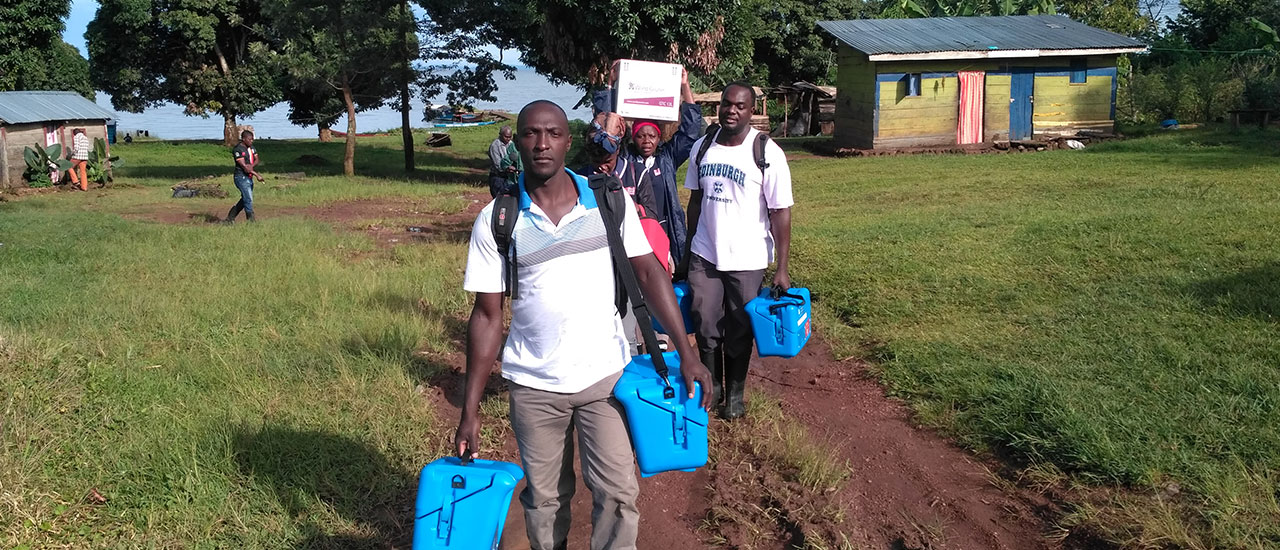 People carrying vaccine carriers and credo boxes in Uganda