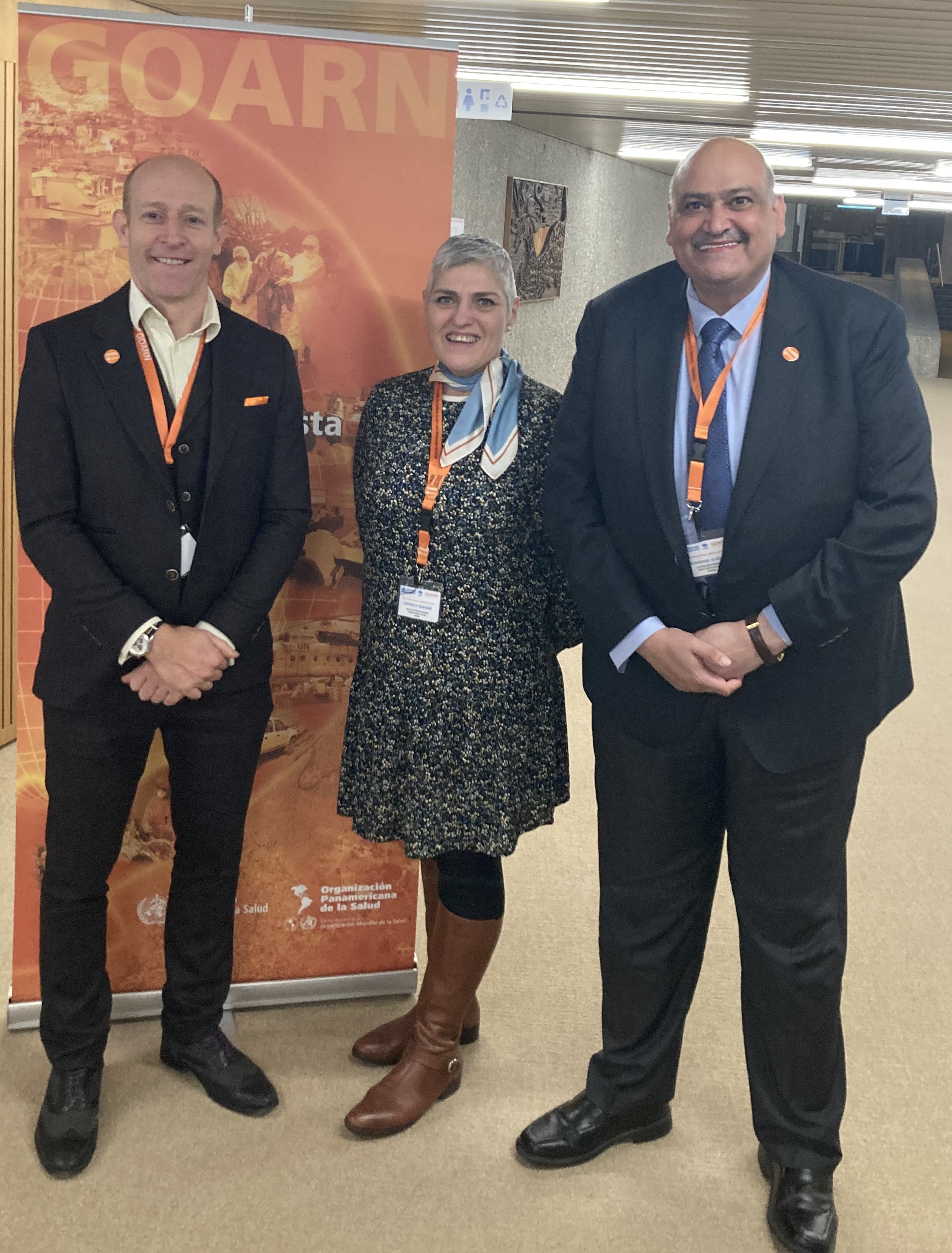 Ed Newman and two other individuals standing in front of GOARN promotional banner