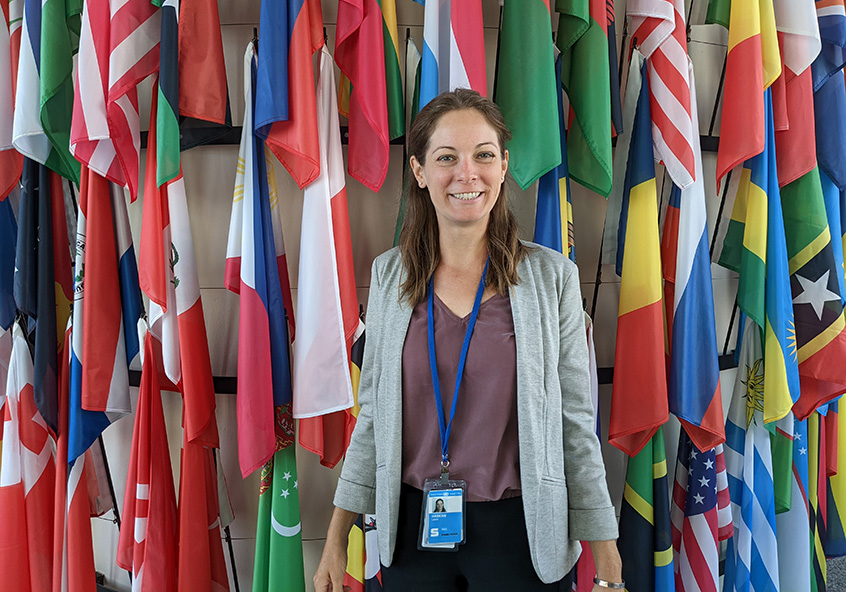 Laura Haskins in front of several national flags