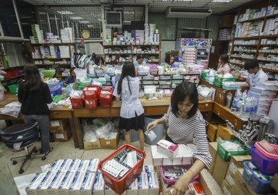 Pharmacists hurriedly prepare medicines to dispense in a general hospital, in Ratchaburi, Thailand
