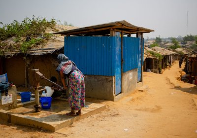 A woman uses a water pump next to a public toilet in the Kutupalong Rohingya refugee camp, Cox’s Bazar, Chittagong, Bangladesh