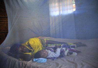 Leila Abdala, 30, with her baby Kairat, 5 months, lie under a bed net at their home in Mtwara, Tanzania