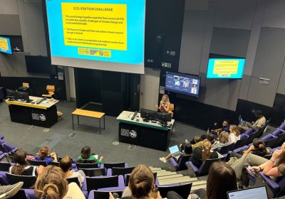 Prof Rosie Green presenting in front of a screen that has information about the ECO-VENTION challenge