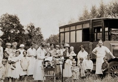A mobile health unit, parked in a Pennsylvania field: women and their children are shown receiving treatment from the unit&#039;s health practitioners. Photograph, 1920/1930? Wellcome Collection