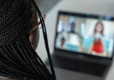 Student in an online meeting looking intoa a laptop.