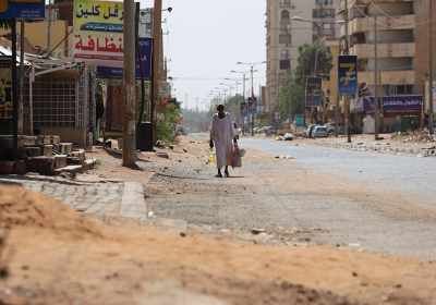 A man walks down a ruined street in war-torn Khartoum.