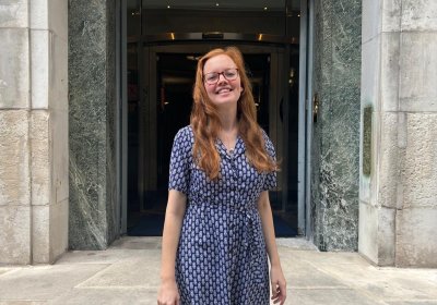 Sophie Moss standing in front of the entrance of LSHTM, Keppel Street