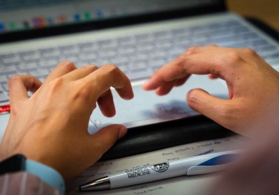 Student typing on a laptop keypad.