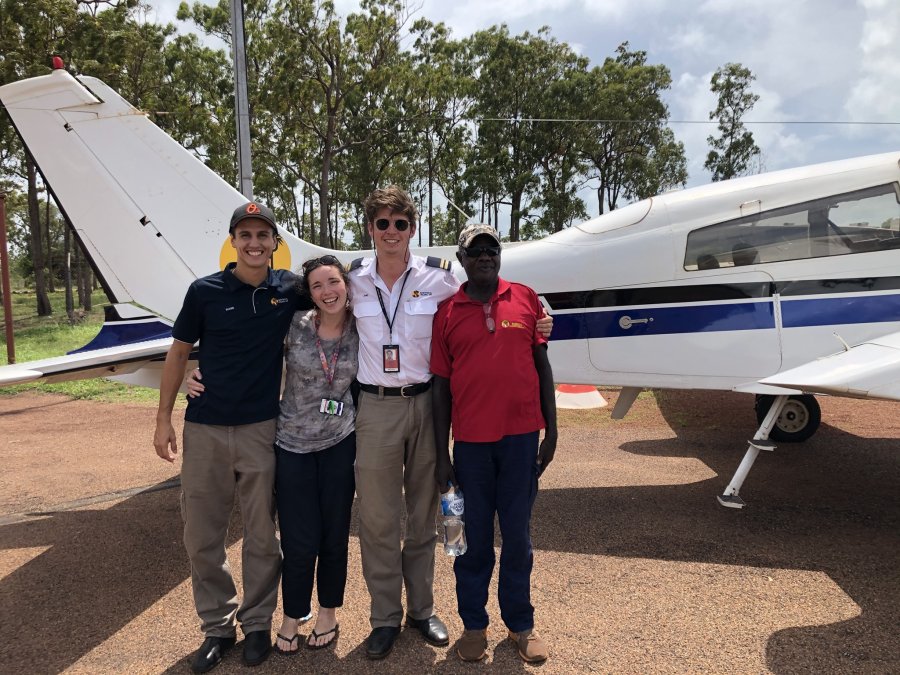 Student and friends standing in front of a small airplane.