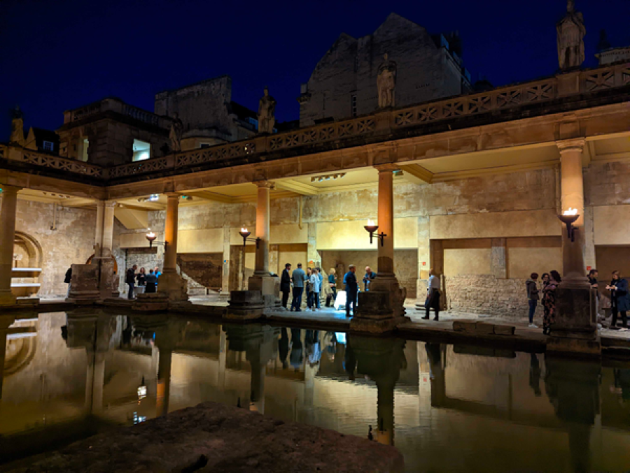  A photo of conference delegates networking at the historical Roman Bath site at night