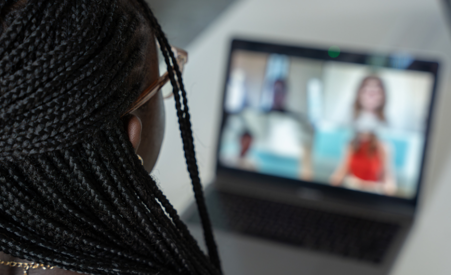 Student in an online meeting looking intoa a laptop.