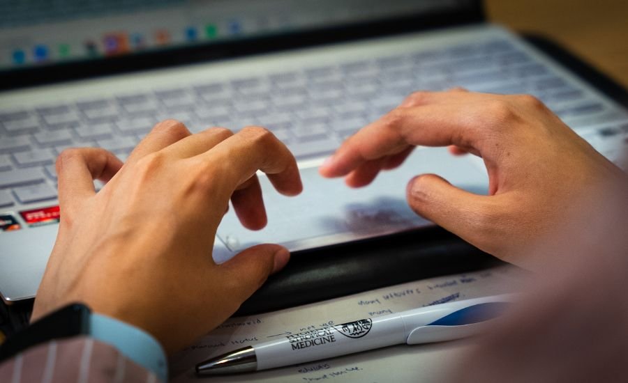 Student typing on a laptop keypad.