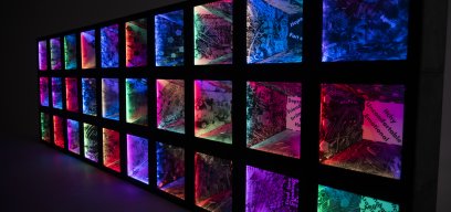 Sculpture created by Julia Vogl and Peter Hudson in collaboration with participants of the &#039;Colouring Adult Eczema&#039; project. 30 illuminated boxes, lit in different colours and marked with various patterns are stacked on each other to form a wall.
