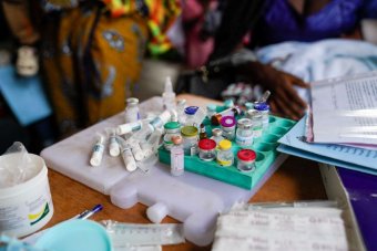 Vaccination vials sit on top of two freezer packs in an attempt to keep them cool in the humid climate of the outdoor ward in Basse Hospital, The Gambia.